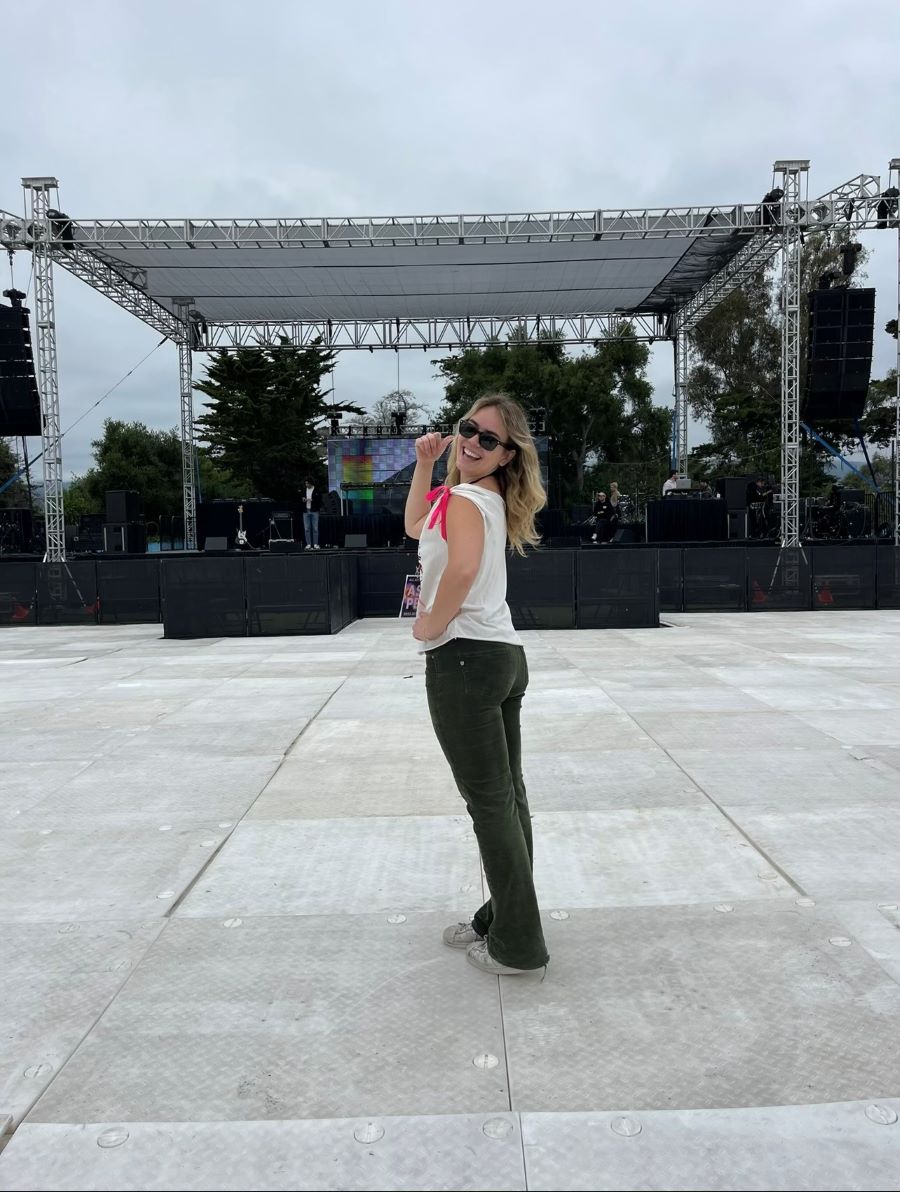 WoodmenLife member Grace F. poses for the picture. She is standing in front of an empty outdoors stage.