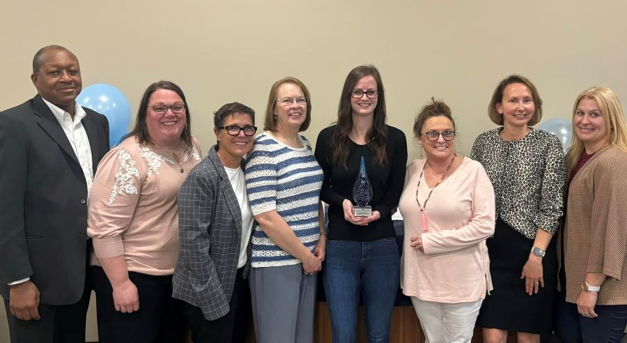 A group of eight WoodmenLife associates pose with the award from the Eastern Nebraska Office on Aging (ENOA) in recognition of WoodmenLife's support for Meals on Wheels.