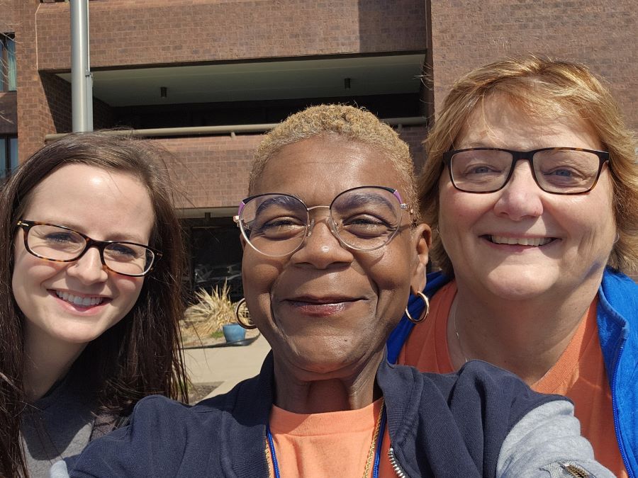 Three women take a selfie while volunteering for Meals on Wheels.