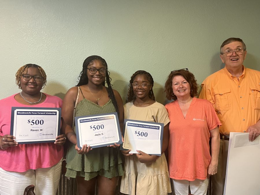 Three young people each hold certificates representing their $500 scholarship awards. They are joined by two adults, representing WoodmenLife and their chapter.