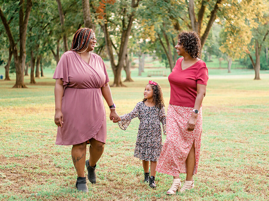 WoodmenLife member Desarea Thompson walks holding hands with her goddaughter, Rose, and her mother, Vilena Thompson.