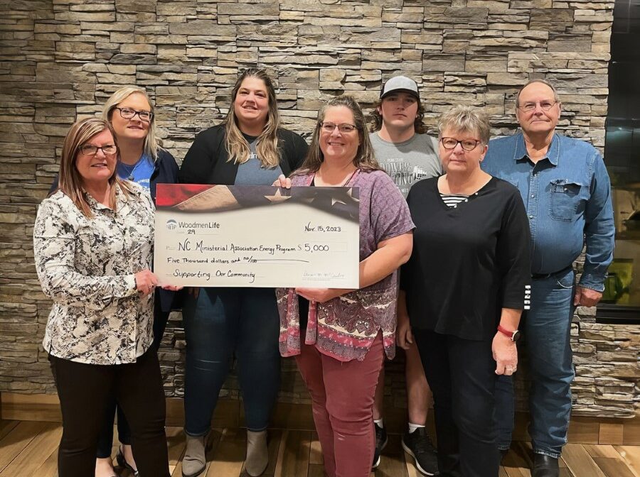 Seven people stand together holding an oversized check for $5,000 made out to the "NC Ministerial Association Energy Program."