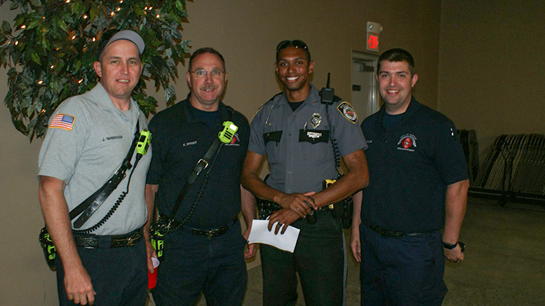 Three firefighters and a sheriff pose for a picture.