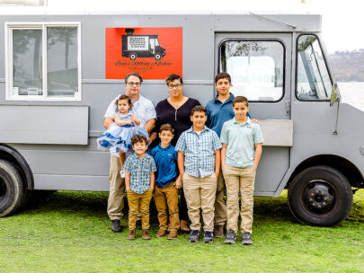 The Baher family, which consists of Chris, Lydia and their six children, stand in front of their food truck, Lena's Rolling Kitchen. They love that their business includes the whole family.