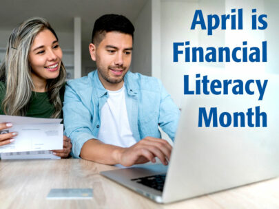 Stock image of a man and woman looking at a laptop. On the image are the words "April is Financial Literacy Month"