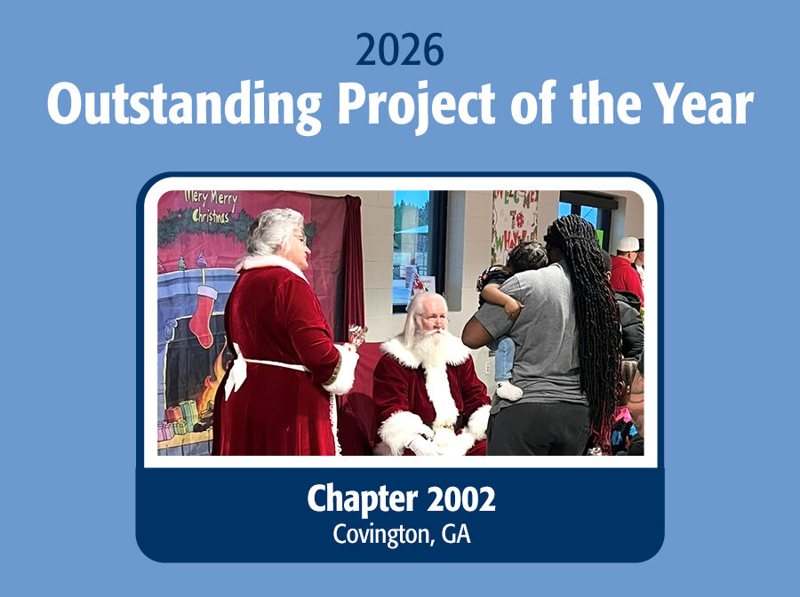 Graphic says "2026 Outstanding Project of the Year" across the top, and "Chapter 2002, Covington, GA" across the bottom. In the middle is a photo of man carrying a small child up to see people dressed as Santa Claus and Mrs. Claus. The background of the graphic is a medium blue.