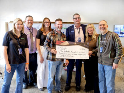 Photo shows seven people standing with an oversized WoodmenLife-branded check. The check is made out to the Arthritis Foundation in the amount of $17,625.