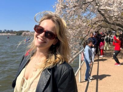 WoodmenLife member Grace F. is pictured outdoors on a walkway alongside a body of water.