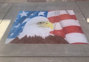Chalk eagle atop a waving patriotic flag
