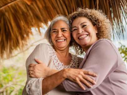 Stock photo shows two women smiling and hugging.