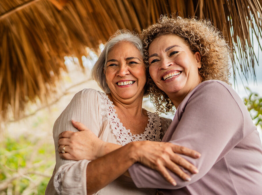Stock photo shows two women smiling and hugging.