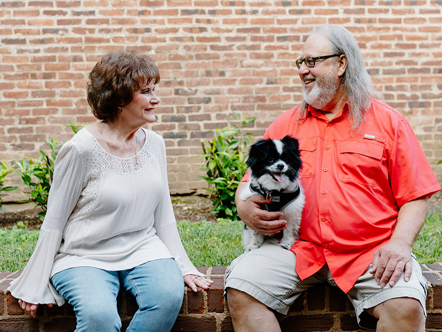 WoodmenLife member Deral "Butch" Venable poses for a photo with his wife, Barbara. He is holding a dog.