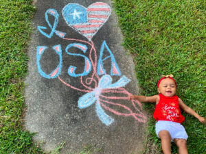 Baby girl with a patriotic chalk art drawing