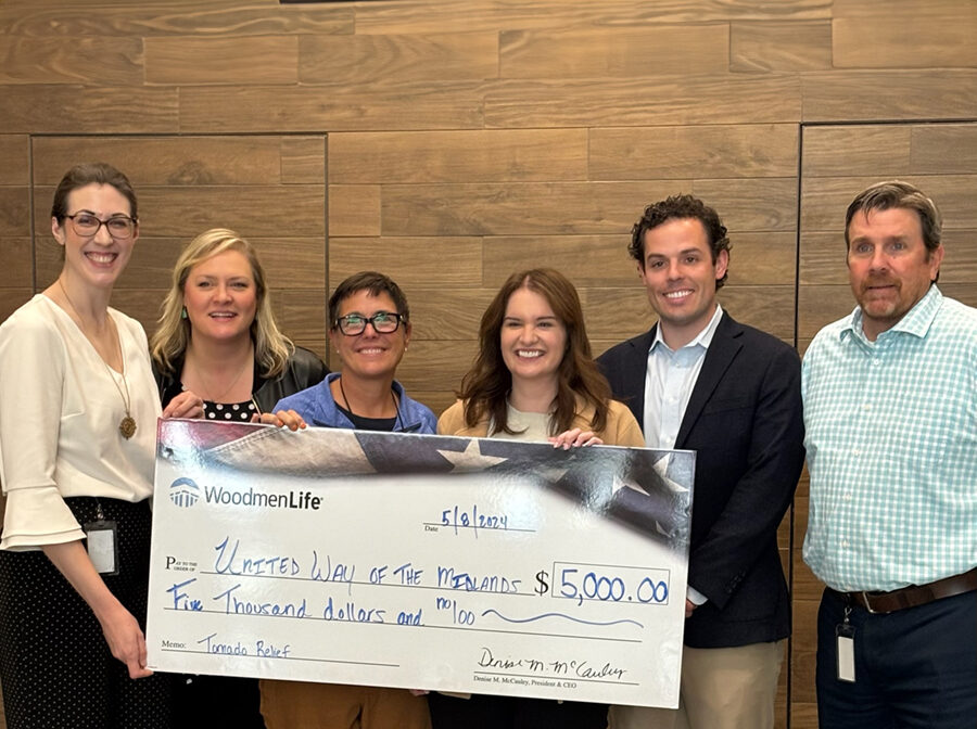 Six people stand with an oversized check. The $5,000 donation is for United Way of the Midlands to help with tornado relief.