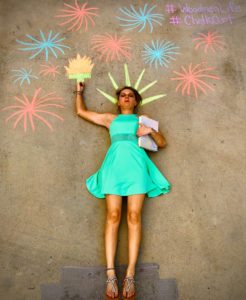 Girl dressed as the Statue of Liberty with chalk art fireworks