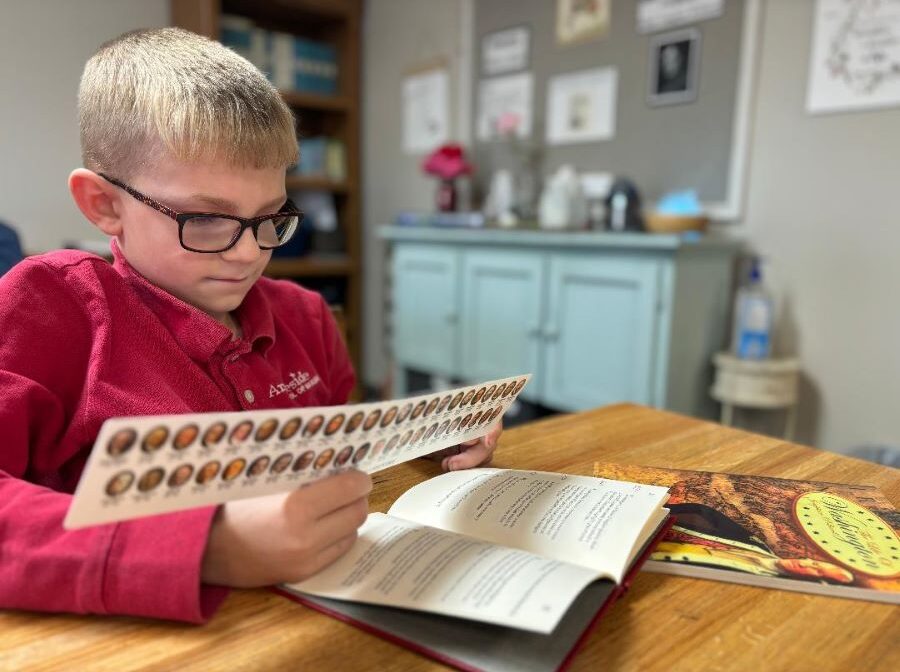 A second-grade student looks at his ruler, which has the faces of all the U.S. presidents on the back.